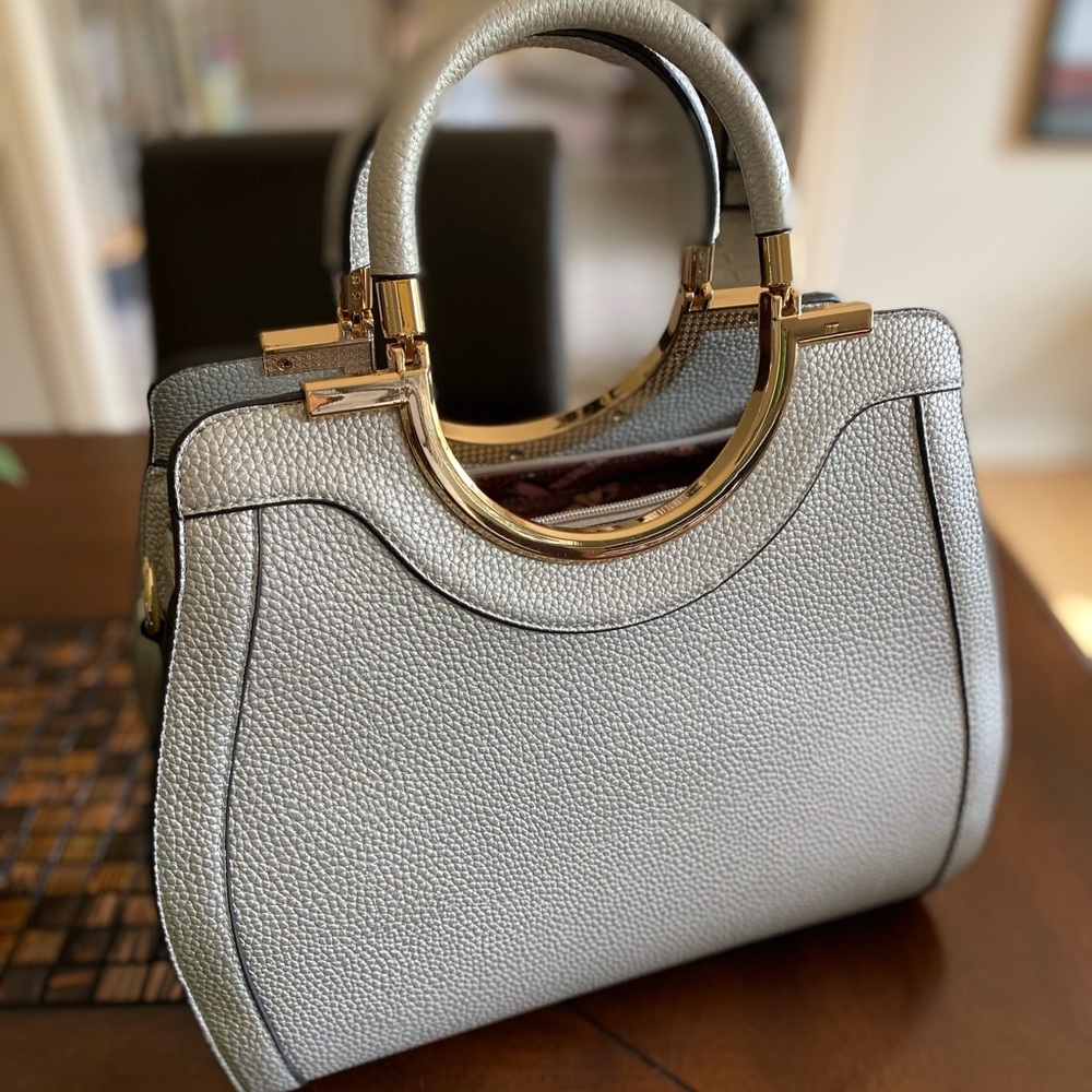 Brand new, beautiful silver purse with adjustable and detachable shoulder strap.